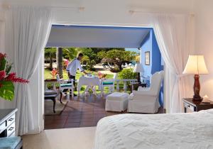 een slaapkamer met een bed en een tafel en stoelen bij Jamaica Inn in Ocho Rios