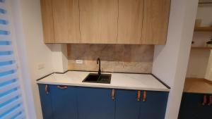a kitchen with blue cabinets and a sink at 85th Pool View 2 Rooms Apartament in Popeşti-Leordeni +1 photo