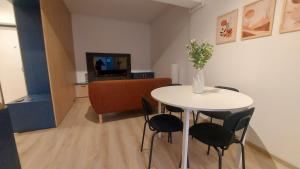 a living room with a table and chairs and a television at 85th Pool View 2 Rooms Apartament in Popeşti-Leordeni