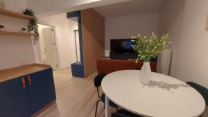 a room with a table with a vase of flowers on it at 85th Pool View 2 Rooms Apartament in Popeşti-Leordeni