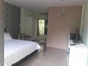 a bedroom with a bed and a tv on a desk at Pingpong 's house Koh chang in Ko Chang
