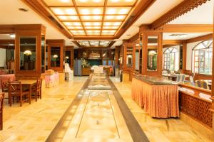 a restaurant with tables and chairs in a room at Royal Twins Palace Hotel in Pattaya