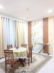 a dining room with a table and chairs and a painting at KASIH JERAI HOMESTAY, Gurun, Guar Chempedak in Guar Chempedak