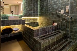 a green tiled bathroom with a sink and a tub at Spa Motel - Radial Leste in São Paulo