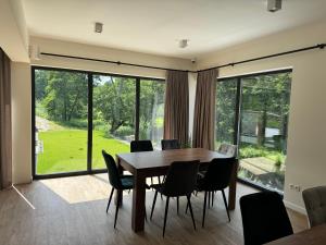 a dining room with a table and chairs and a large window at Szum Rzeki - Noclegi nad Brdą - Bory Tucholskie in Nadolna Karczma