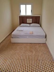 a bedroom with a bed with a checkered floor at casa celia in Asilah