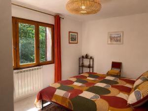a bedroom with a bed and a window at La Bastide Rempelin in Aix-en-Provence