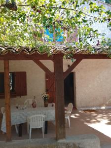 a patio with a table and chairs under a pavilion at La Bastide Rempelin in Aix-en-Provence