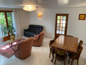 a living room with a couch and a table and chairs at La Bastide Rempelin in Aix-en-Provence