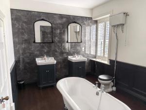 a bathroom with two sinks and a tub and a toilet at Bardon Hill Manor in Coalville