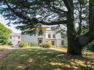 a large white house with a tree in the foreground at Bardon Hill Manor in Coalville