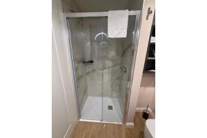 a shower with a glass door in a bathroom at Mariano Suites in Stigliano