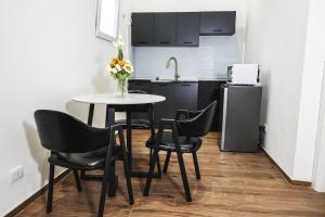 a kitchen with a table and chairs and a refrigerator at Leonida Residence in Taranto