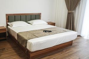 a bedroom with a large bed with a green headboard at Leonida Residence in Taranto