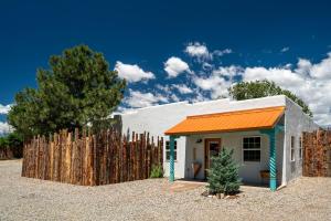 a small house with an orange roof next to a fence at LUXX Taos Motor Lodge in Taos