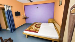 a bedroom with a bed with a purple wall at new crown hotel in Indore