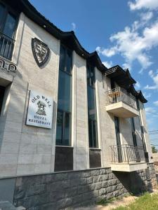 a building with a sign on the side of it at Old Well Hotel in Tsaghkadzor