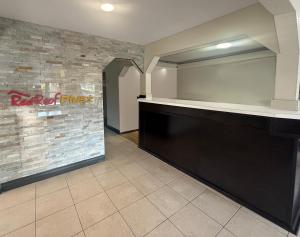 a restaurant with a counter in a room with a brick wall at Red Roof PLUS Centralia in Centralia