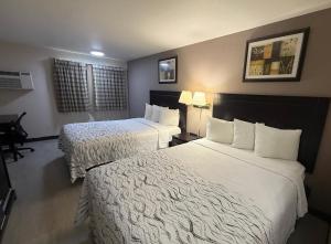 a hotel room with two beds with white sheets at Red Roof PLUS Centralia in Centralia