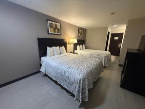 a hotel room with two beds with white sheets at Red Roof PLUS Centralia in Centralia