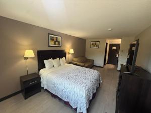 a bedroom with a large bed and a television at Red Roof PLUS Centralia in Centralia