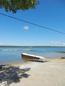a boat sitting on the shore of a body of water at Bayshore Cottages in Wiarton