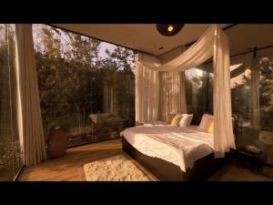 a bedroom with a canopy bed and a large window at منتجع سفاري ديور in At Turbīyah