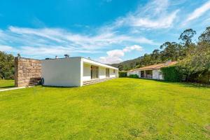 a large yard with a white building in a field at Portugal Active Oliveiras Farm in Viana do Castelo
