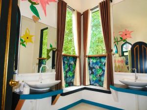 a bathroom with two sinks and two windows at MG Chateau Resort in El Nido
