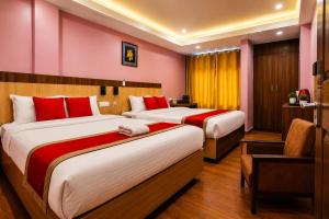two beds in a hotel room with red walls at Hotel City Center in Bhairāhawā