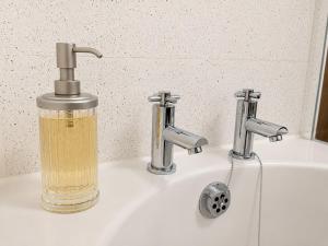 a soap dispenser sitting on top of a sink at Howgills Apartments in Sedbergh +58 photos