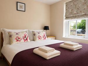 a bedroom with a bed with two towels on it at Howgills Apartments in Sedbergh