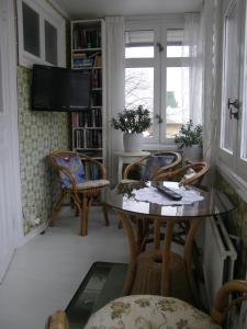 a living room with a table and chairs and a tv at Monicas Rumsuthyrning in Borgholm