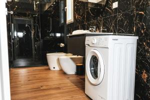 a bathroom with a washing machine and a toilet at Leonida Residence in Taranto
