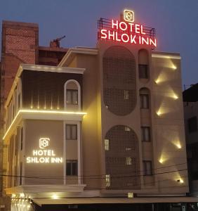 a hotel with a sign on the side of a building at Hotel Shlok Inn in Somnath