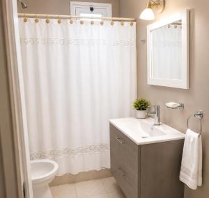 a bathroom with a sink and a shower curtain at Tierra Mora Casas de alquiler in Villa Gesell +16 photos