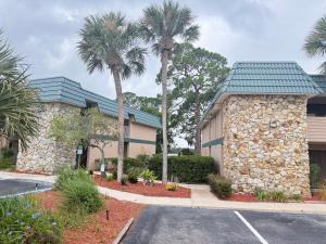 a building with palm trees next to a parking lot at Lifetime of Vacations in Orlando
