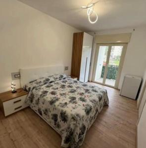 a bedroom with a bed with a floral bedspread and a window at B&b Antonia in SantʼAntonio Abate
