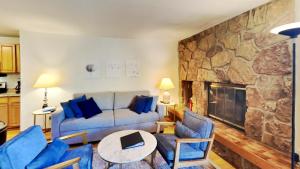 a living room with a couch and chairs and a stone wall at 135 Marina Place in Dillon