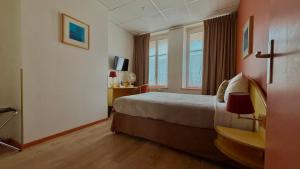 a hotel room with a bed and a window at Logis-Hôtel des Oliviers in Thionville +59 photos