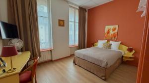 a hotel room with a bed and a desk and window at Logis-Hôtel des Oliviers in Thionville
