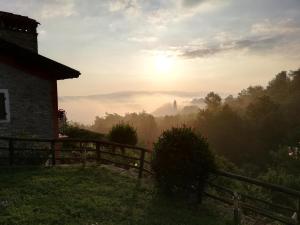 a view of the sunrise from a house with a fence at Cà del Prino in Millesimo +18 photos