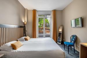 a hotel room with a large bed and a blue chair at Hotel Molière in Cannes +114 photos