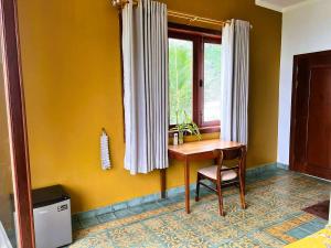 a table and chair in a room with a window at Family-friendly accomodation with sea view in Kaôh Kon