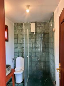 a bathroom with a toilet and a glass shower at Family-friendly accomodation with sea view in Kaôh Kon