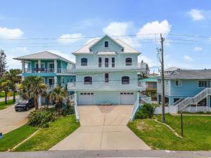 a large blue house with a driveway at Sea Manor in New Smyrna Beach