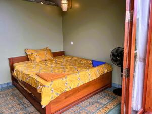 a bedroom with a bed with a yellow comforter at Family-friendly accomodation with sea view in Kaôh Kon