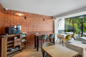 a restaurant with tables and chairs and a tv on a wall at Hotel Molière in Cannes
