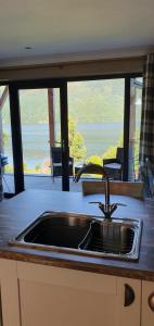 a kitchen sink with a view of the ocean at Carrick Chalets in Cairndow +48 photos