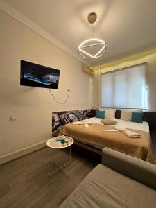 ein Zimmer mit einem Bett, einer Couch und einem Fernseher in der Unterkunft Skypiea Hotel in Yerevan
